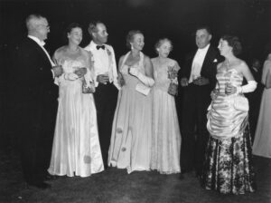 a group of older men and women dressed in tuxedos and long formal gowns